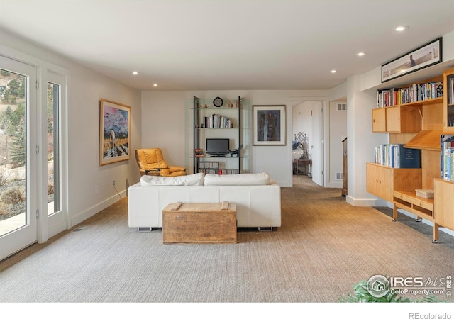 carpeted living room with visible vents, recessed lighting, and baseboards