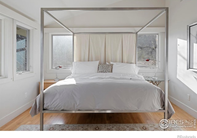 bedroom featuring wood finished floors and baseboards