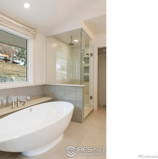 full bath with recessed lighting, a stall shower, tile patterned floors, a soaking tub, and tile walls