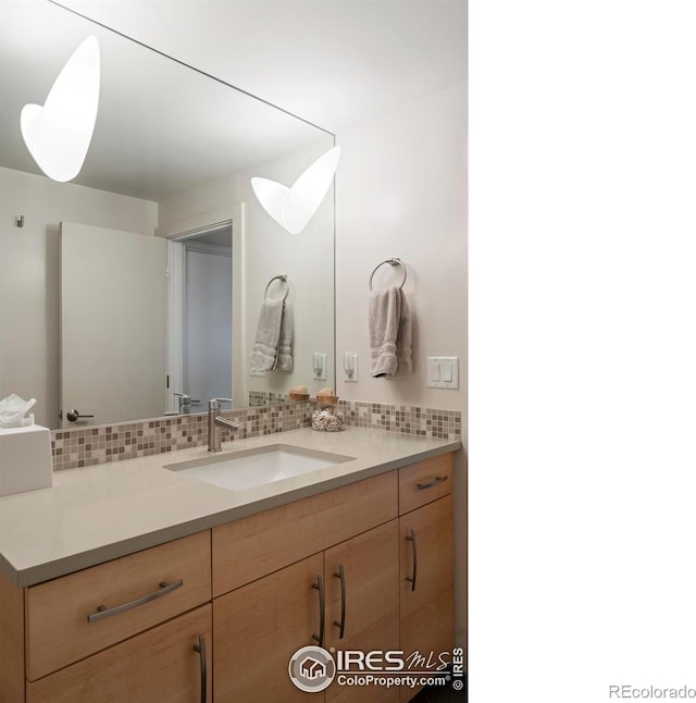 bathroom with decorative backsplash and vanity