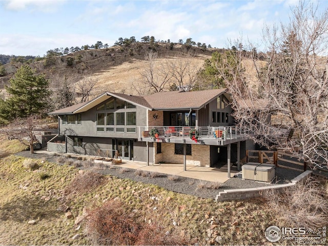 back of property with a patio and a hot tub