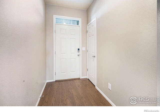 doorway to outside featuring dark wood finished floors and baseboards