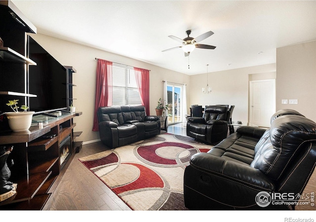 living area featuring ceiling fan, baseboards, and wood finished floors