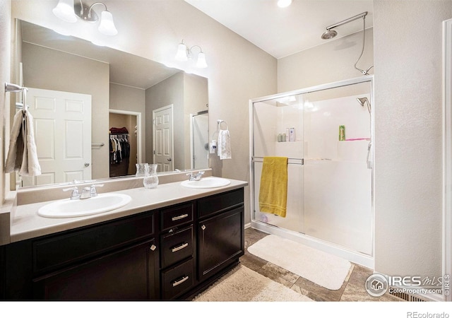 full bathroom with a sink, a shower stall, and a spacious closet