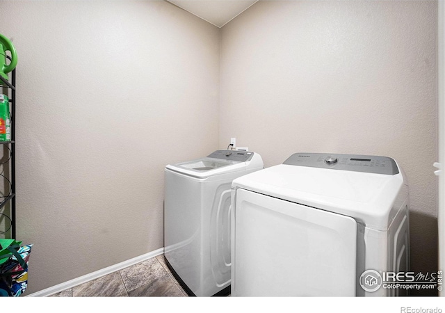 clothes washing area with laundry area, baseboards, and independent washer and dryer