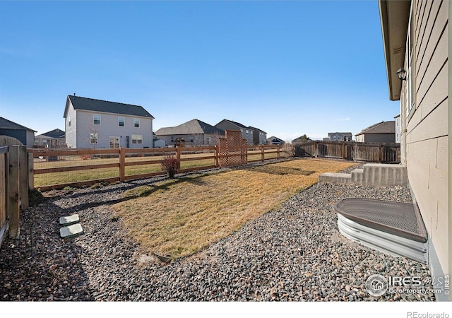 view of yard featuring a fenced backyard and a residential view