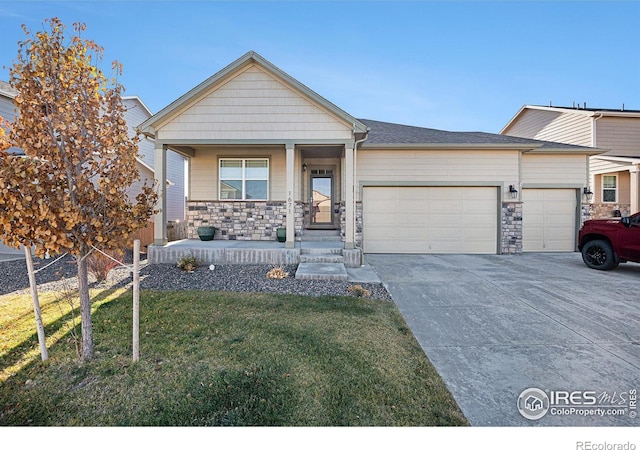 view of front of house with a garage, a front yard, covered porch, and stone siding