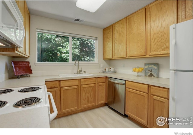 kitchen featuring light wood-type flooring, white appliances, and sink