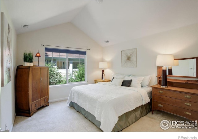 carpeted bedroom with lofted ceiling