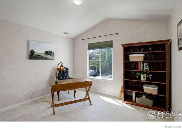 carpeted home office featuring vaulted ceiling