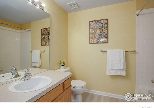 full bathroom with shower / bathing tub combination, hardwood / wood-style floors, vanity, and toilet