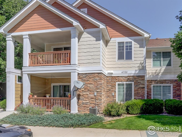 view of front of property featuring a balcony and central AC unit