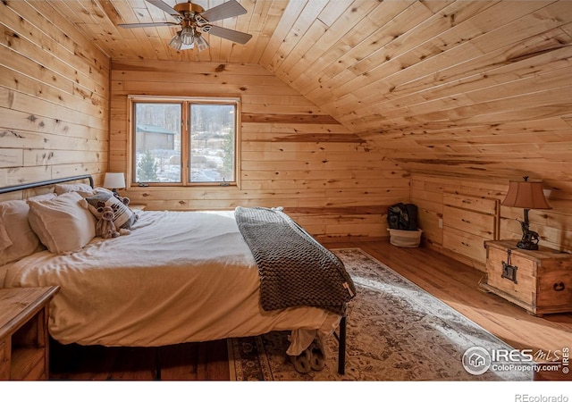 bedroom with ceiling fan, wooden ceiling, light hardwood / wood-style floors, lofted ceiling, and wood walls