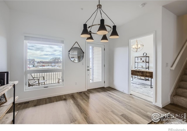 entryway featuring hardwood / wood-style flooring and a notable chandelier