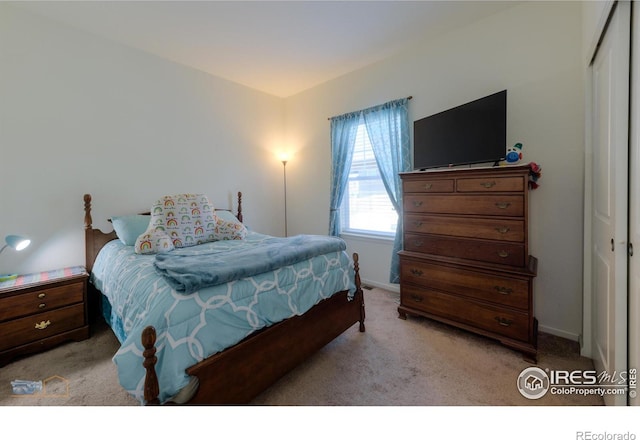 bedroom with light carpet and a closet