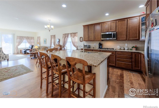 kitchen with a sink, a chandelier, appliances with stainless steel finishes, and a healthy amount of sunlight