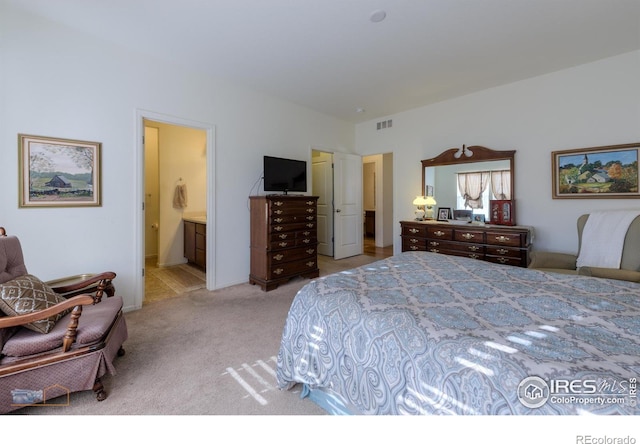 bedroom featuring visible vents, connected bathroom, and light colored carpet
