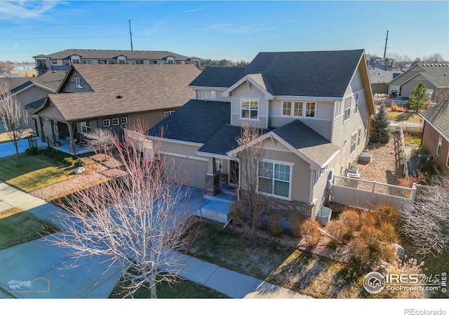 view of front facade featuring central AC unit, concrete driveway, a shingled roof, a garage, and a residential view