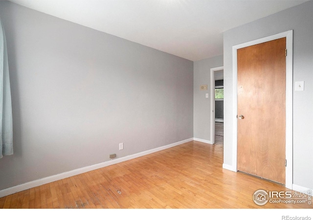 unfurnished room with a baseboard radiator and light wood-type flooring