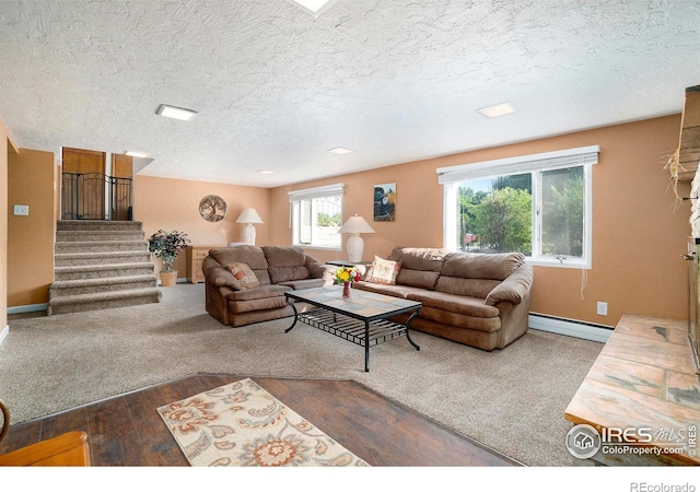 living room featuring dark wood-type flooring, baseboard heating, and a textured ceiling