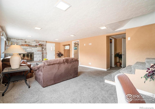 living room featuring a textured ceiling, a stone fireplace, and carpet flooring