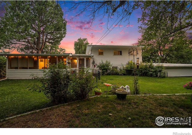 back house at dusk with a yard