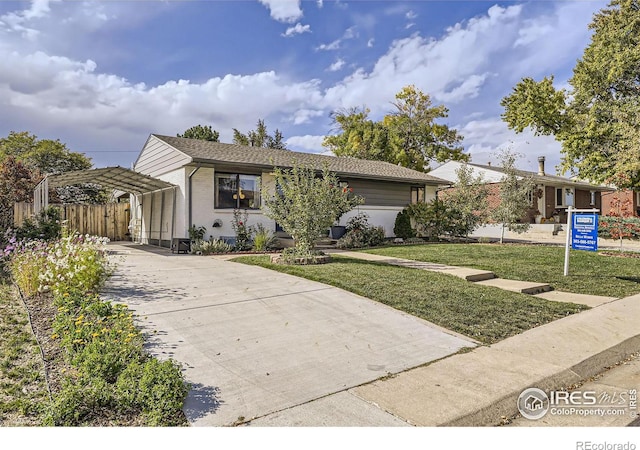 ranch-style house featuring a carport and a front lawn