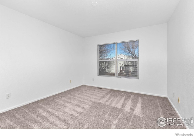 carpeted empty room with baseboards