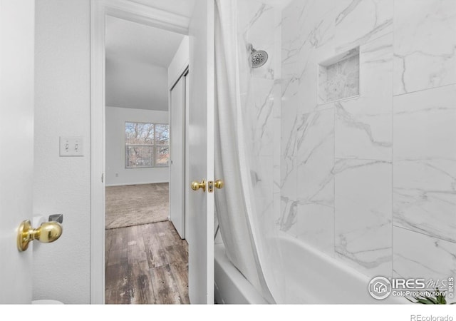 bathroom featuring wood finished floors and shower / tub combo with curtain