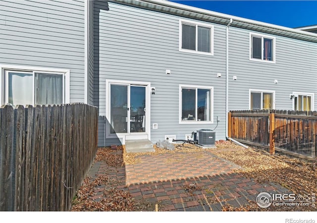 back of property featuring central air condition unit, a fenced backyard, a patio, and entry steps