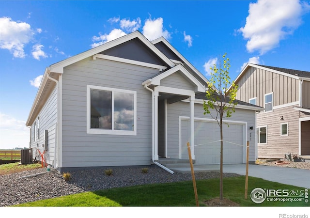 view of front of home with a garage and central AC