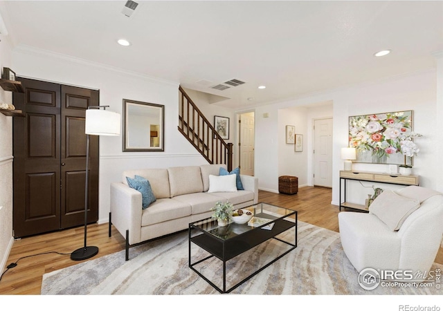 living room featuring light hardwood / wood-style flooring and ornamental molding