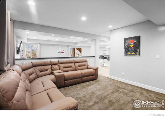 carpeted living room with a tray ceiling