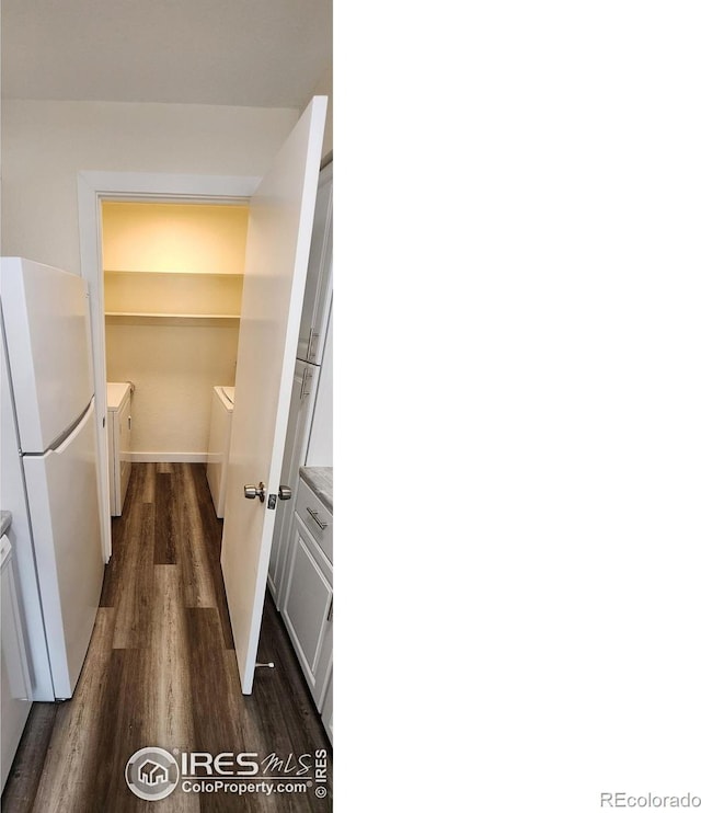 interior space featuring white cabinets, dark hardwood / wood-style flooring, white fridge, and washer and dryer