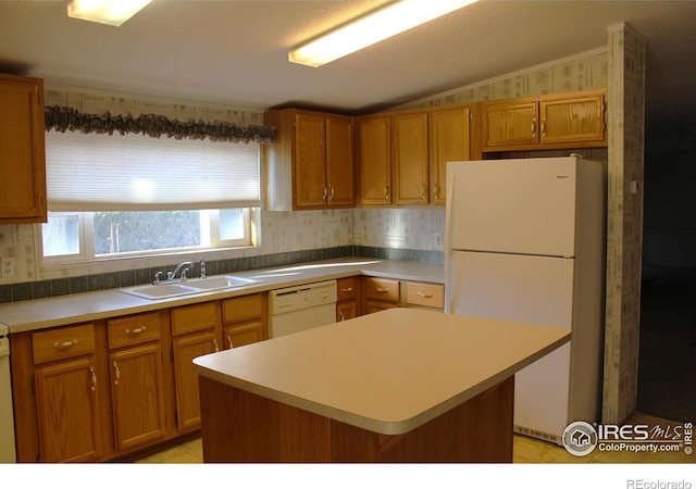 kitchen with lofted ceiling, a center island, white appliances, and sink