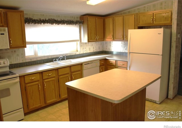 kitchen with white appliances, a center island, and sink