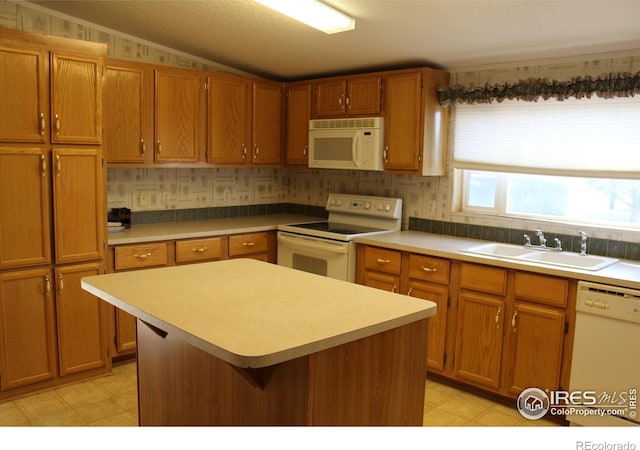 kitchen featuring lofted ceiling, sink, a kitchen island, and white appliances