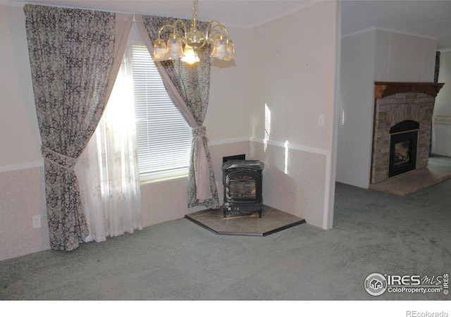 living room featuring carpet, a wood stove, plenty of natural light, and a notable chandelier