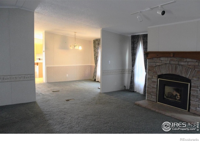 carpeted living room with a fireplace, a chandelier, and track lighting