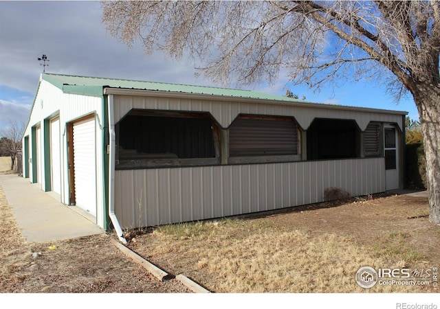 view of side of home featuring a garage and an outdoor structure