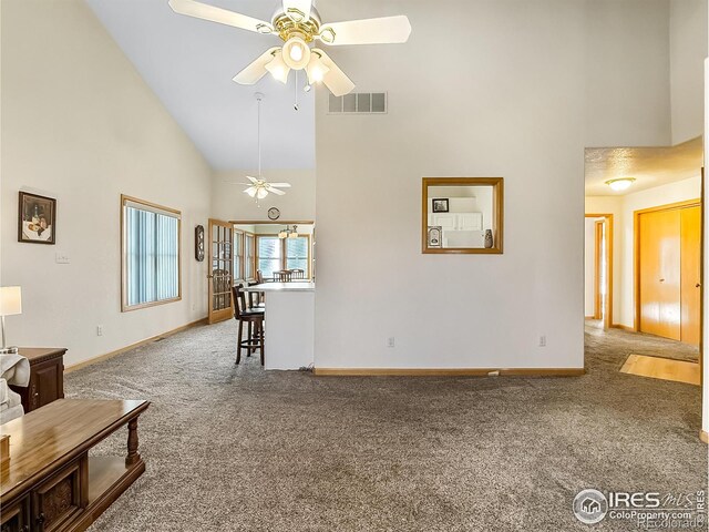 carpeted living room with high vaulted ceiling and ceiling fan