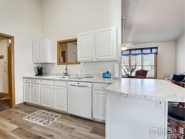 kitchen featuring kitchen peninsula, white cabinetry, white dishwasher, and light hardwood / wood-style floors