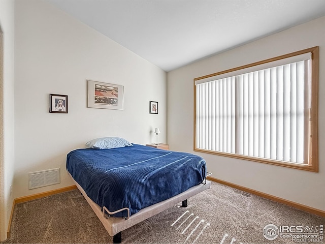 bedroom with carpet flooring, lofted ceiling, and multiple windows