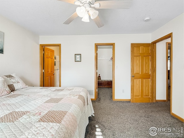 carpeted bedroom with a walk in closet, ceiling fan, a closet, and a textured ceiling