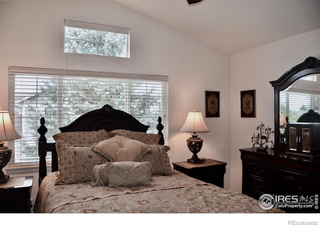 bedroom with vaulted ceiling and multiple windows