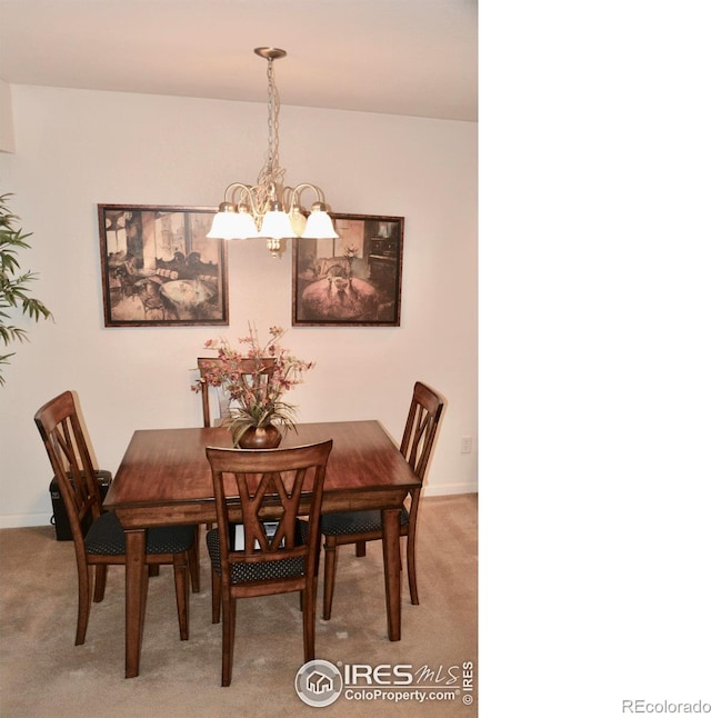 carpeted dining space with a notable chandelier