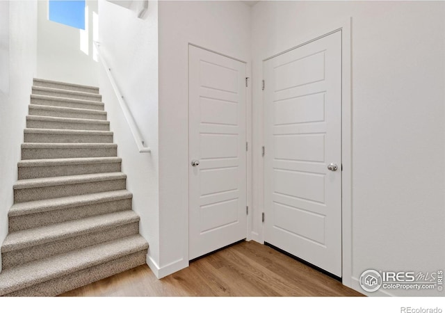 stairs featuring hardwood / wood-style flooring