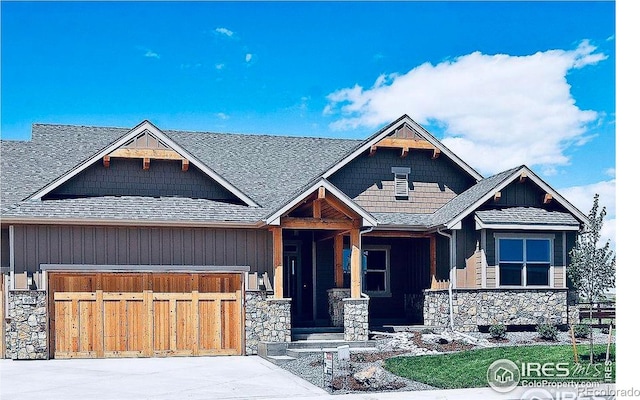 craftsman-style home with stone siding, roof with shingles, an attached garage, and concrete driveway