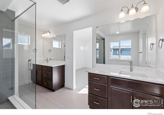 bathroom with vanity, a shower with door, and tile patterned flooring