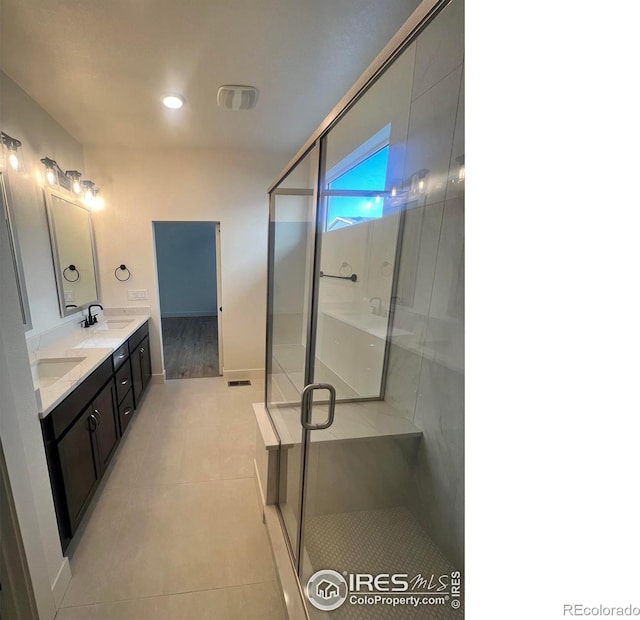 bathroom featuring tile patterned flooring, vanity, and a shower with shower door